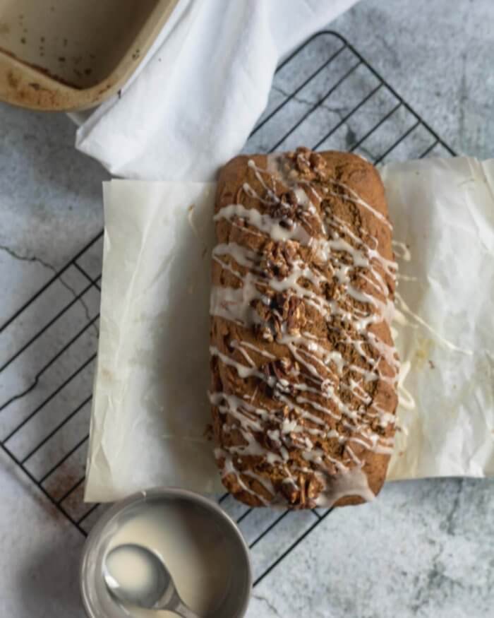 maple pumpkin bread on a cooling rack drizzled with maple glaze
