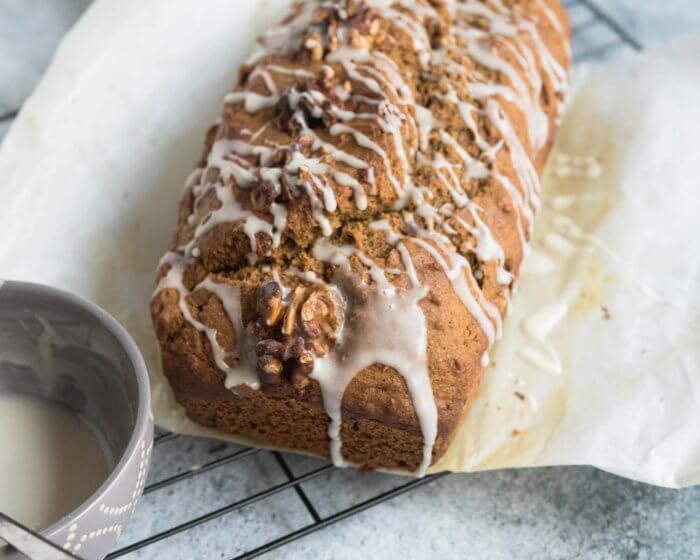 maple pumpkin bread just glazed on parchment paper