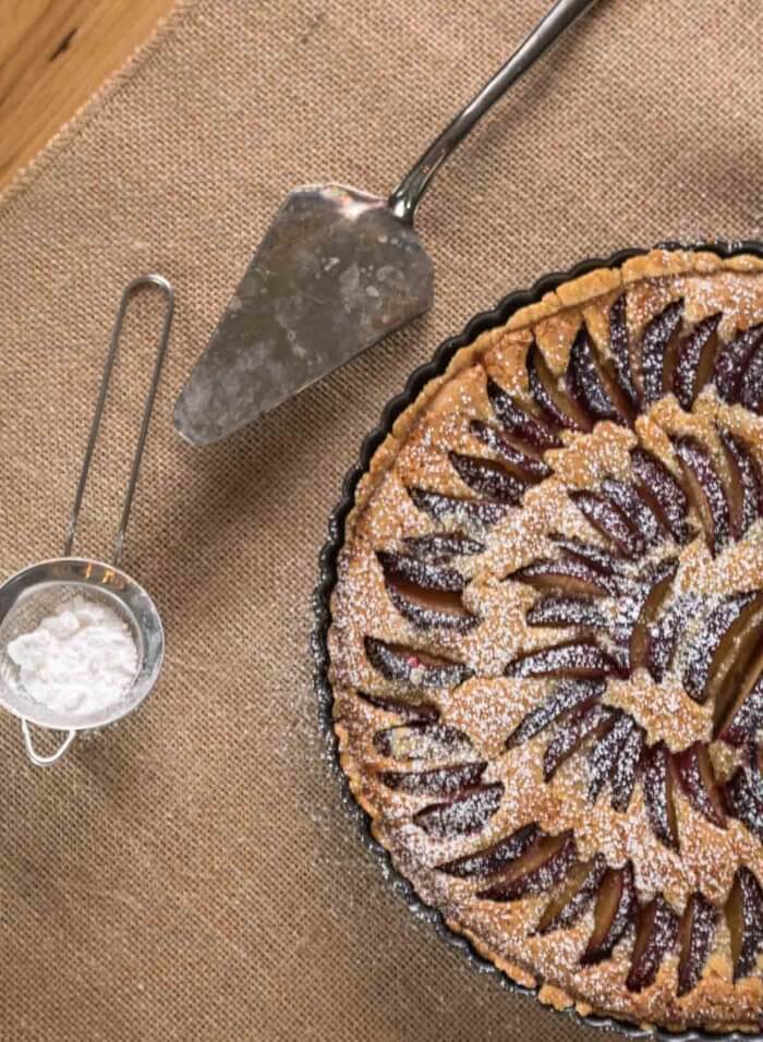 plum tart  with almonds sprinkled with icing sugar