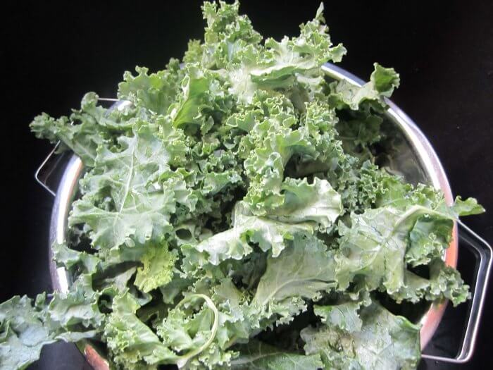 washing kale in a colander