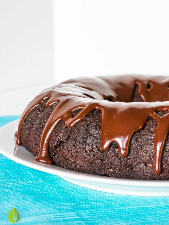 chocolate bundt cake with chocolate glaze on a white cake plate