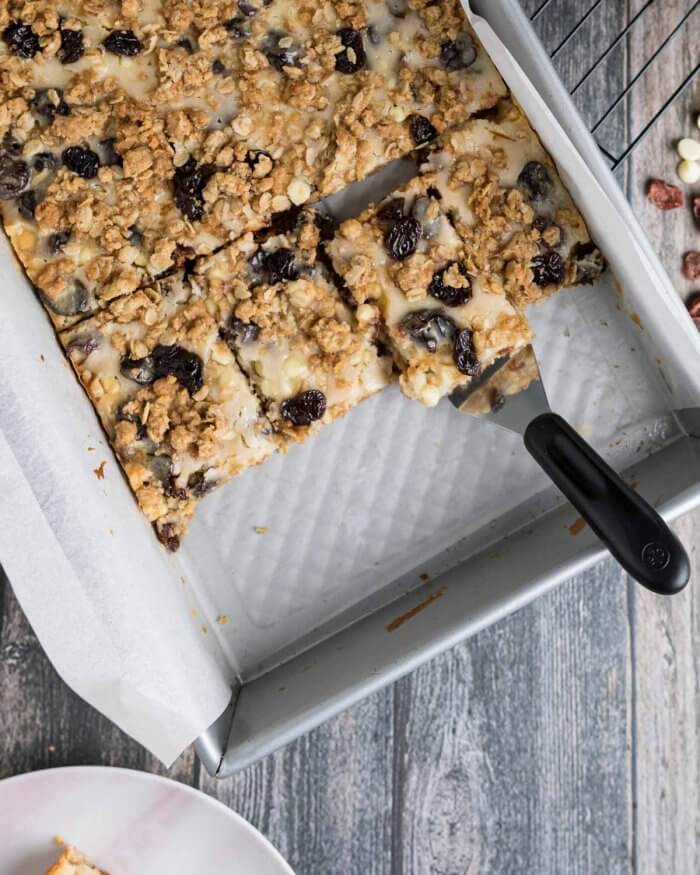 white chocolate and cranberry oatmeal cookie bars cut and served from baking tray