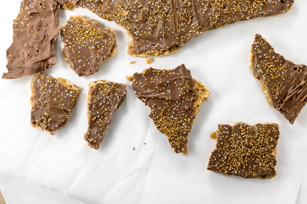 Chocolate Saltine Toffee pieces on parchment paper