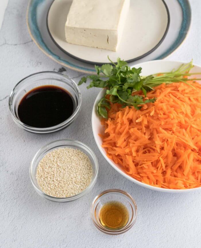 ingredients for carrot and tofu scramble - carrots, tofu, soy sauce, sesame seeds, cilantro