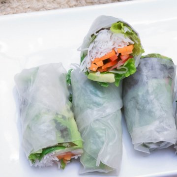 vegan fresh salad wraps stacked on a square white plate