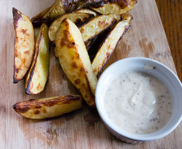 oven roasted fries with dijon dipping sauce on a wooden serving board