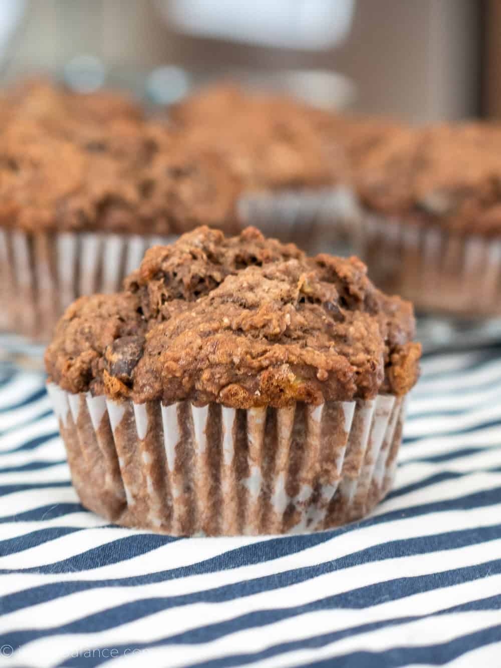 double chocolate whole wheat and banana muffins on a blue and white striped table cloth