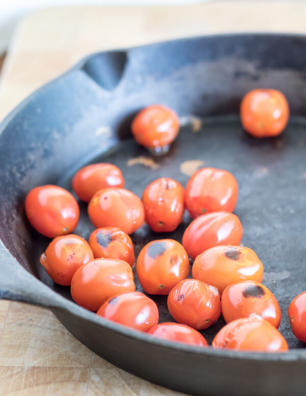 blackened cherry tomatoes in a cast iron skillet 