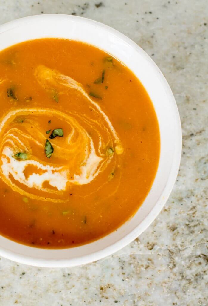 cream tomato soup in serving soup bowl wtih a swirl of cream on top