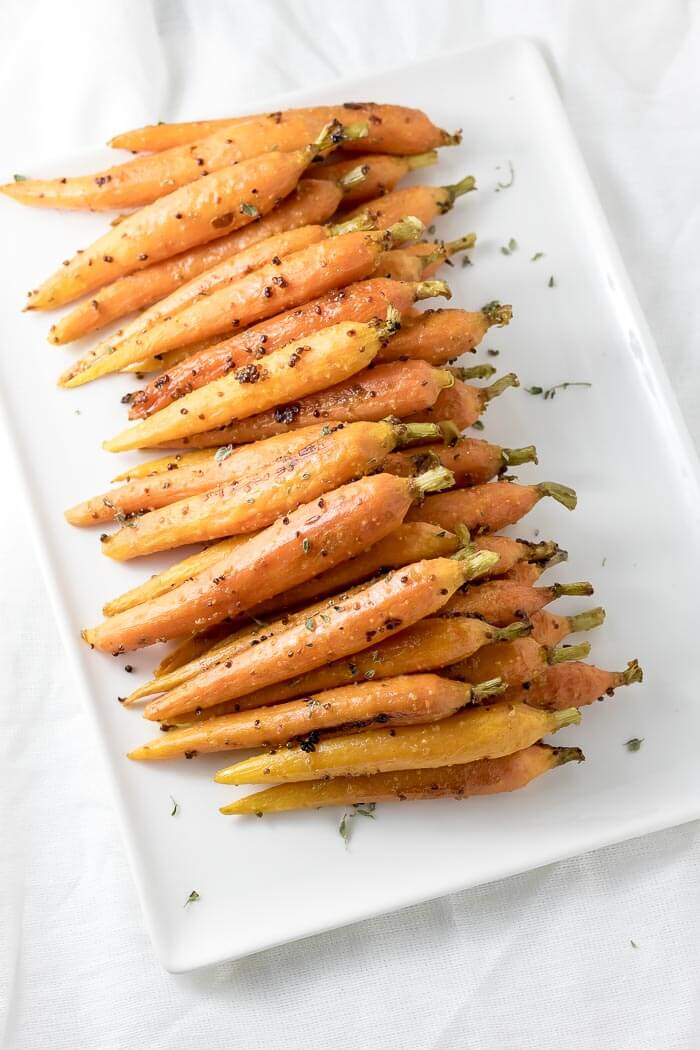 maple glazed carrots on a plater sprinkled with thyme