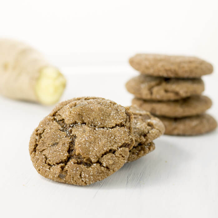 ginger molasses cookies stacked with fresh ginger
