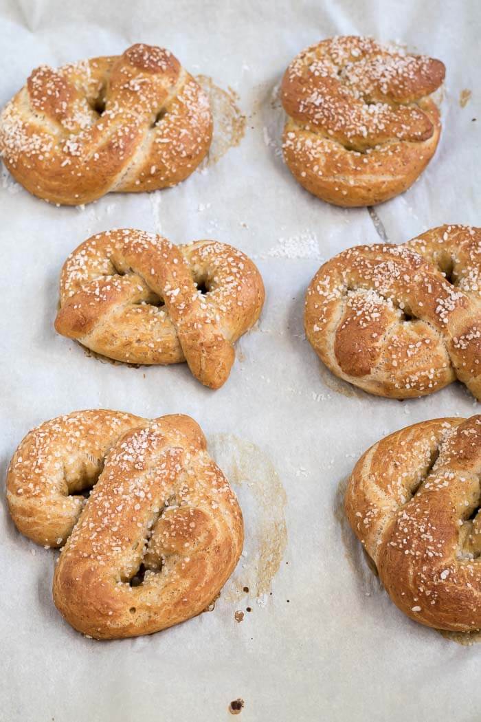 soft baked pretzels on a baking sheet with salted tops