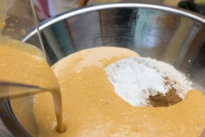 adding wet ingredients to dry ingredients for pumplin pie waffles