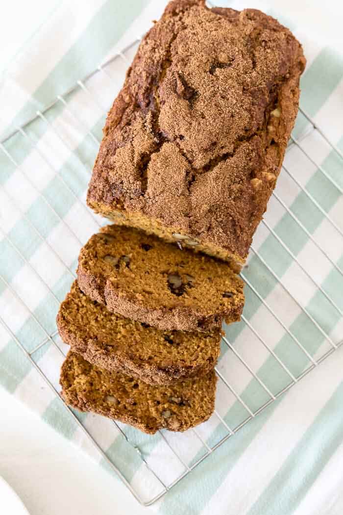Pumpkin spice bread, sliced on a blue and white kitchen towel