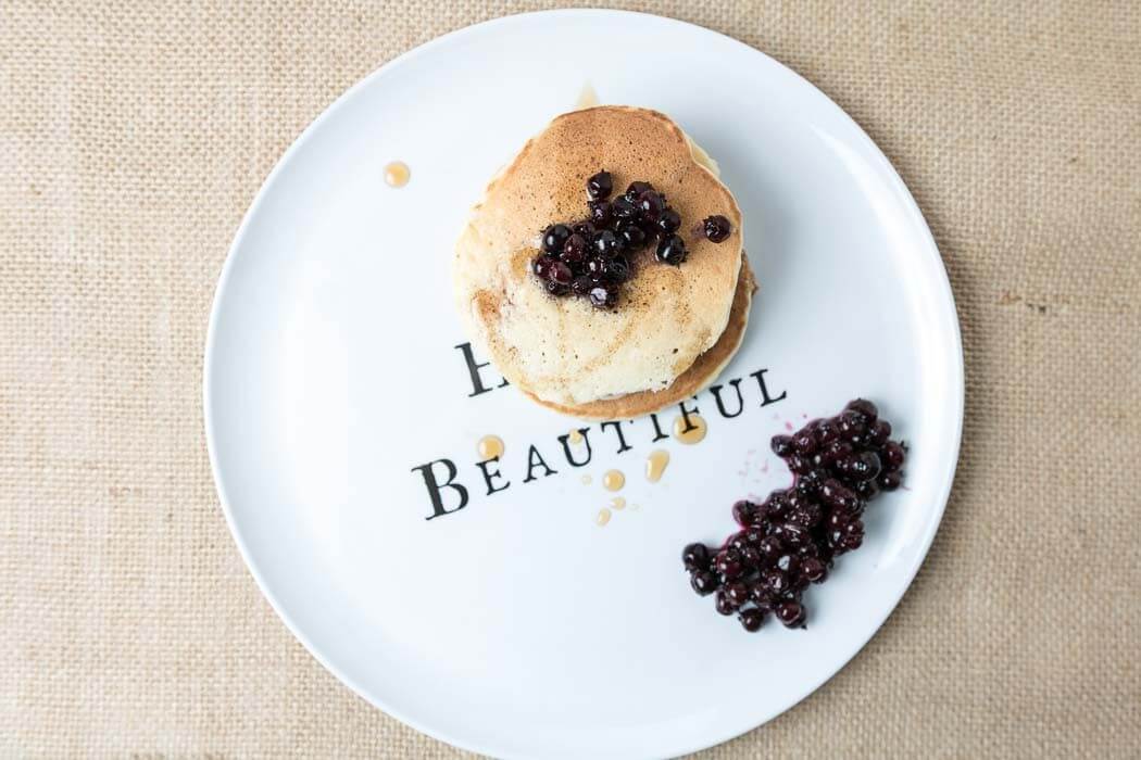 top view of banana pancakes with blueberries on beautiful plate