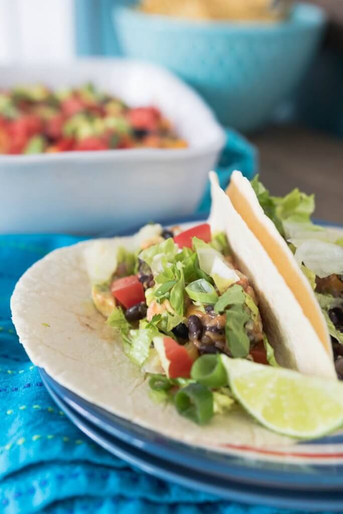 vegetarian taco bake served in soft taco shells with lettuce and lime