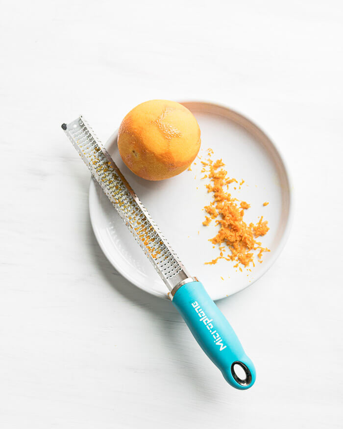 orange and zest on a plate with microplane grater