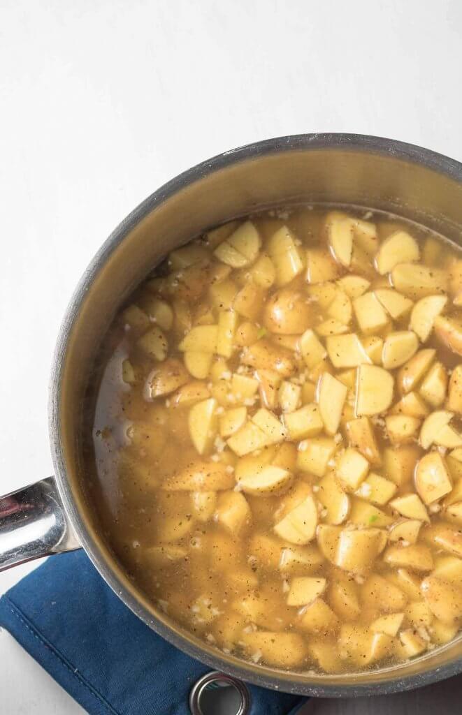 diced potatos in a pot with seasonings ready to simmer