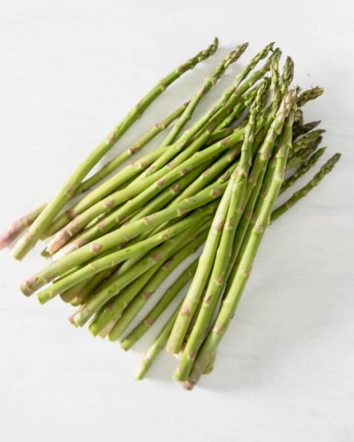 raw asparagus on a white board