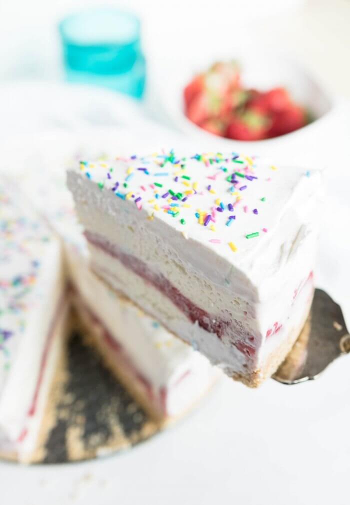 a slice of strawberry vanila ice cream cake with sprinkles