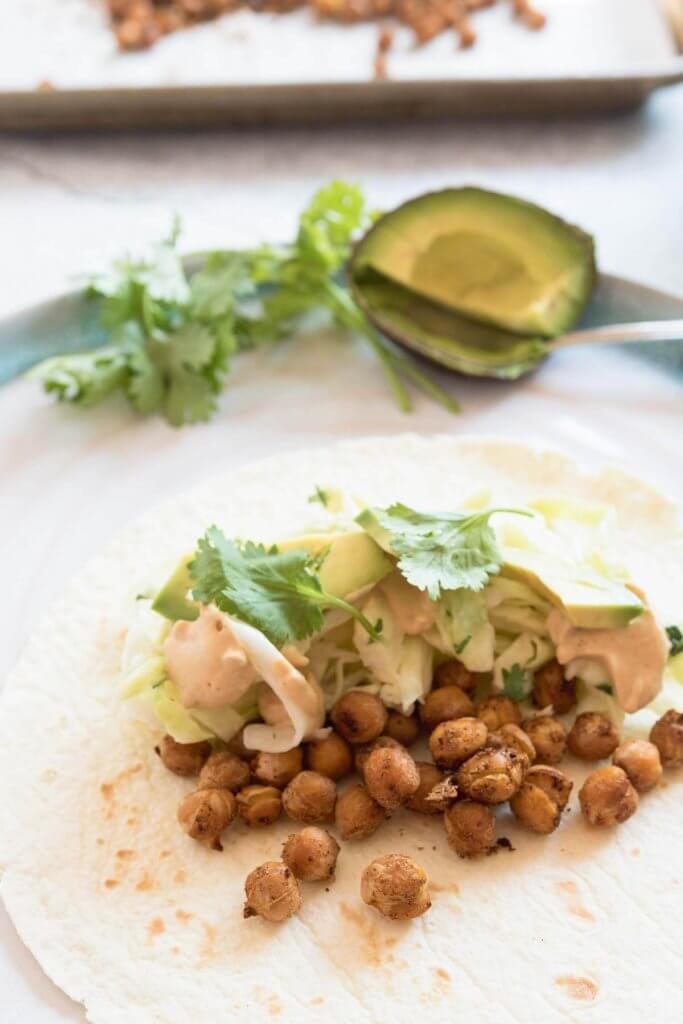 soft taco shell with roasted taco spiced chickpeas, slaw and avocado