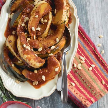 acorn squash slow roasted in a sweet and tangy sauce on a serving platter