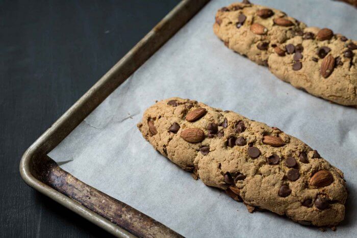 chocolate almond biscotti on a baking sheet after the first baking