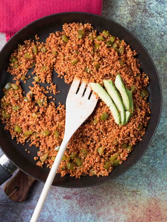 Spanish millet in a skillet with avocado