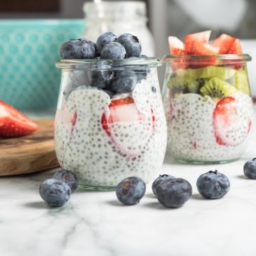 chia seed pudding in 2 glass jars with blueberries, strawberries and kiwi