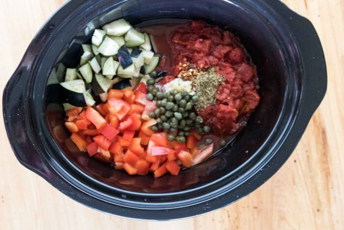 ingredients for eggplant stew in a slowcooker - diced eggplant, red pepper, canned tomatoes, capers