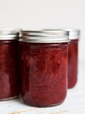 strawberry banana jam in half pint jars on a white background