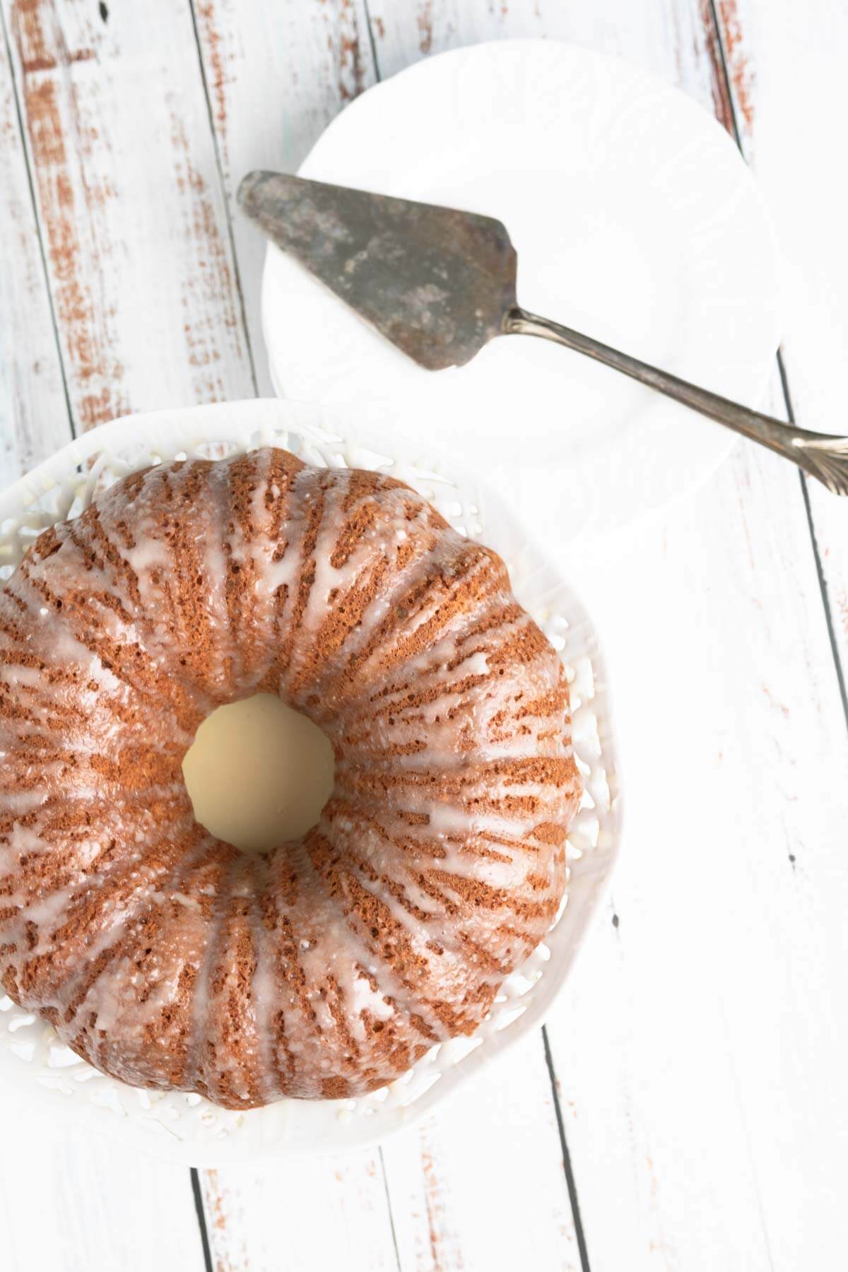 top view of a roasted banan cake on a white background and with a serving spoon