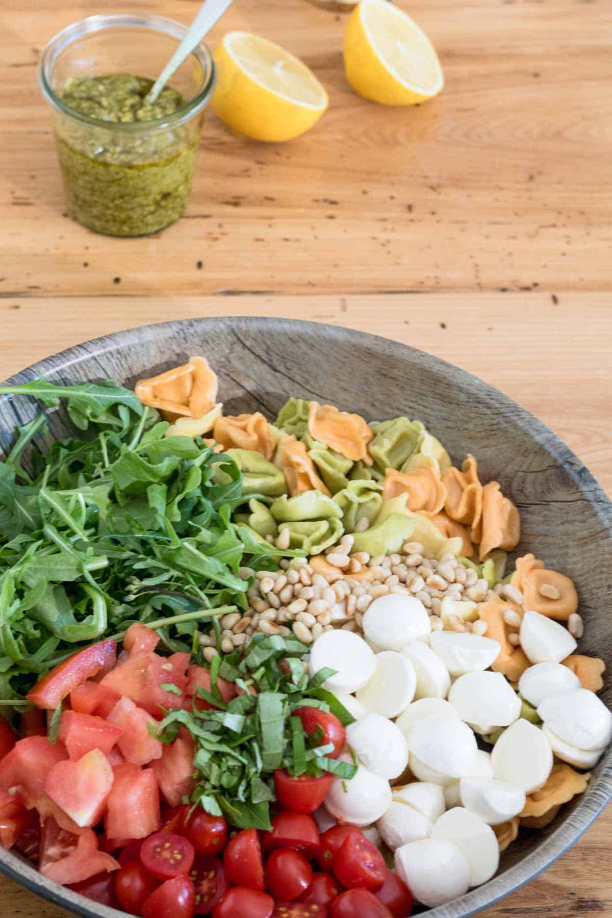 tortellini pasta salad with pesto, arugula, bocconcini and cherry tomatoes ready for tos