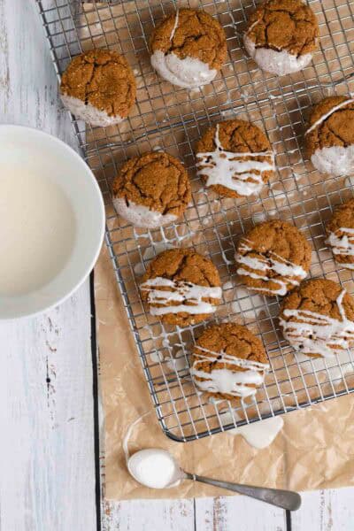 Chai ginger molasses cookies with vanilla cream icing on wire rack.