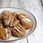 Chai ginger molasses cookies with vanilla cream icing on wire rack.