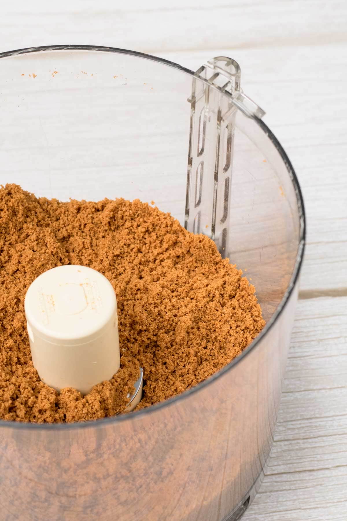 biscoff cookies in a food processor bowl, cookies are ground into fine crumbs